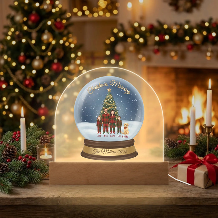 Personalized Christmas Morning snow globe dome plaque glowing with LED light on a cozy fireplace mantel