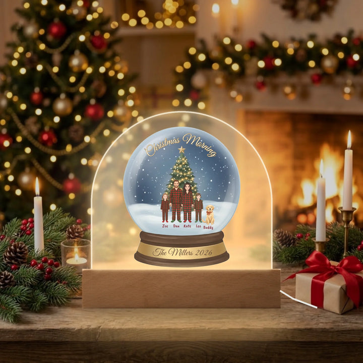 Personalized Christmas Morning snow globe dome plaque glowing with LED light on a cozy fireplace mantel
