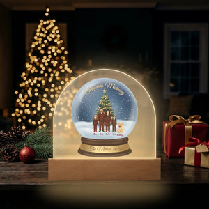 LED dome plaque lit up beside a glowing Christmas tree and presents at night
