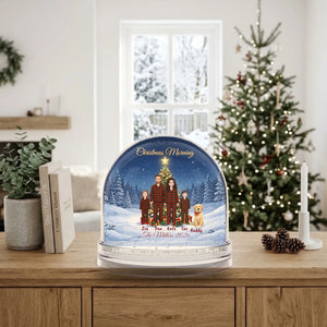 Christmas family snow globe on a sideboard in a bright winter living room