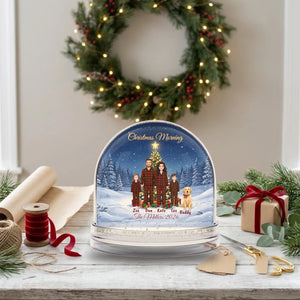 Personalized snow globe Christmas gift on a gift-wrapping table with kraft paper and ribbon
