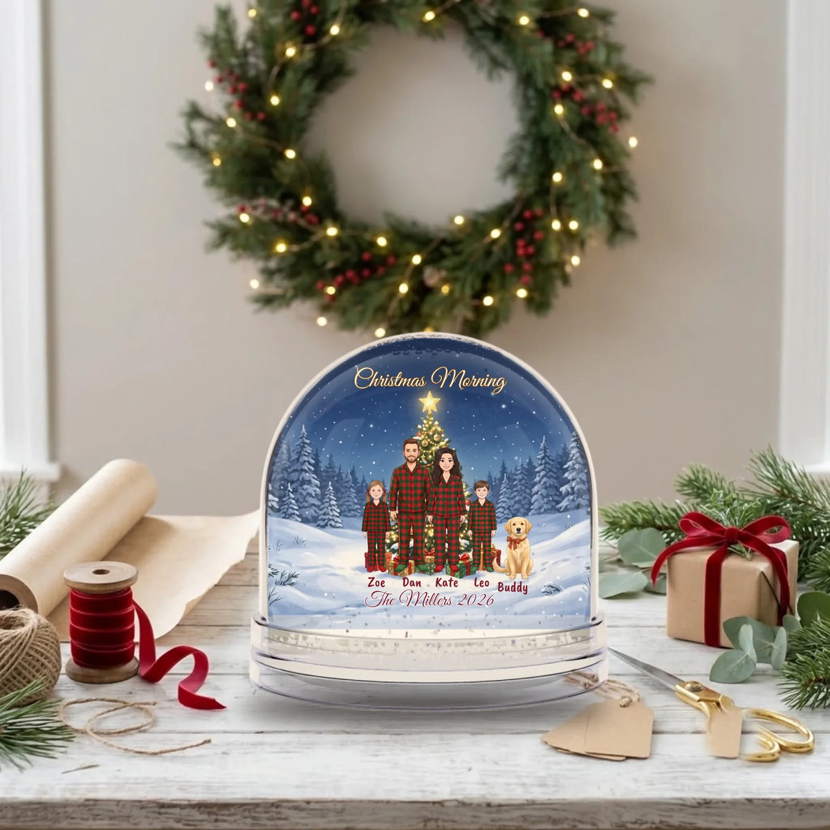 Personalized snow globe Christmas gift on a gift-wrapping table with kraft paper and ribbon